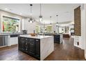 Expansive kitchen with marble countertops, modern black and white cabinetry, hardwood floors, and a central island at 17820 Queensmere Dr, Monument, CO 80132