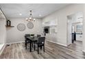 Dining area with neutral walls, decorative lighting, and wood flooring adjacent to open concept kitchen and living room at 20908 E Dorado Cir, Centennial, CO 80015
