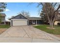 The exterior showcases a quaint blue home with an attached garage, large driveway and mature landscaping at 20908 E Dorado Cir, Centennial, CO 80015