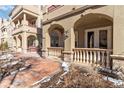 Exterior features arched covered entry, brick walkway, and sculpted, light-colored porch columns at 40 Madison St # 103, Denver, CO 80206