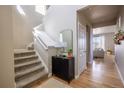 Bright entryway featuring a staircase, modern decor, and hardwood floors, creating a welcoming atmosphere at 476 Hyde Park Cir, Castle Pines, CO 80108