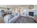 Open-concept living room with a fireplace, neutral tones, and seamless flow to the dining and kitchen area at 476 Hyde Park Cir, Castle Pines, CO 80108