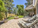 Private backyard featuring a stone fire pit, lounge chairs, and a covered patio perfect for outdoor entertaining at 7782 S Louthan St, Littleton, CO 80120