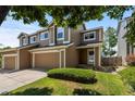 Inviting townhome with a spacious two-car garage, lush green lawn, and appealing curb appeal at 2430 E 109Th Dr, Northglenn, CO 80233
