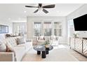 Bright living room featuring large windows, stylish furniture, and a ceiling fan at 14850 Munich Ave, Parker, CO 80134