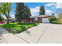 Well maintained lawn, mature trees, with a large driveway leading to a one car garage at 12046 W Green Mountain Dr, Lakewood, CO 80228