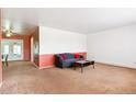 Neutral living room featuring carpeted floors, a large window and a cozy couch at 12046 W Green Mountain Dr, Lakewood, CO 80228