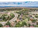 Beautiful aerial view showcasing homes nestled among mature trees in a quiet neighborhood with a scenic mountain view at 8687 N Pinery Pkwy, Parker, CO 80134
