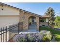 Charming home featuring a brick archway leading to the front entrance and lush landscaping at 10909 W 65Th Way, Arvada, CO 80004