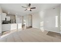 Open-concept living room and kitchen area, features modern ceiling fan and bright natural light at 2992 Oxley St, Strasburg, CO 80136