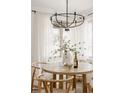 Bright dining area features a round wood table, modern lighting, and sheer curtains at 916 Florence St, Aurora, CO 80010