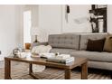 Cozy living room with a gray sofa, a wood coffee table, and a neutral plaid rug at 916 Florence St, Aurora, CO 80010