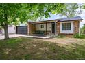 A charming one-story brick home features a front porch and an attached two-car garage at 3881 S Bahama St, Aurora, CO 80013