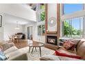 Bright living room with high ceilings, fireplace, large windows, and hardwood floors at 6375 S Jackson St, Centennial, CO 80121