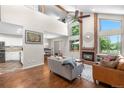 Open-concept living area with a fireplace, vaulted ceilings, and hardwood floors at 6375 S Jackson St, Centennial, CO 80121
