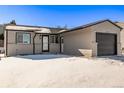 Updated Ranch home exterior with snow covered yard and attached garage at 16930 E Wagontrail Pkwy, Aurora, CO 80015