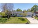 Attractive single-Gathering home with a neatly landscaped front yard, mature trees, and an attached garage at 1322 Wicklow St, Boulder, CO 80303