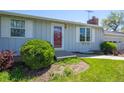 Close-up of a home's entrance with a vibrant front door, neatly trimmed bushes, and a welcoming pathway at 1322 Wicklow St, Boulder, CO 80303