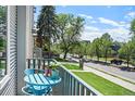 Charming balcony view features a cozy seating area and overlooks the street, filled with lush trees at 2726 Federal Blvd # 1, Denver, CO 80211