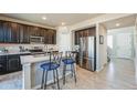 Modern kitchen featuring stainless steel appliances, dark wood cabinetry, and a breakfast bar at 16737 Lake Helen Blvd, Mead, CO 80542