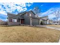 Spacious gray home featuring a well-maintained lawn, two-car garage, and inviting curb appeal at 4630 E 135Th Way, Thornton, CO 80241