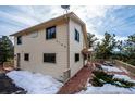 View of the home's side, highlighting the deck and surrounding trees at 9189 Fallen Rock Rd, Conifer, CO 80433