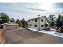 Two-story house with attached garage and deck, nestled in a wooded area at 9189 Fallen Rock Rd, Conifer, CO 80433