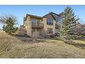 View of back exterior featuring upper and lower balconies and multiple windows at 11925 W Ida Dr, Littleton, CO 80127