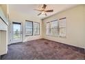 Bright bedroom featuring a ceiling fan, multiple windows, and a glass door to the balcony at 11925 W Ida Dr, Littleton, CO 80127