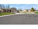 Neighborhood street view of a well-kept home with mature trees and a green lawn at 4510 E 121St Pl, Thornton, CO 80241