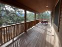 Covered wooden deck with an outdoor table and chairs overlooking mountain scenery at 4924 S Indian Trail, Evergreen, CO 80439