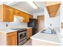 Well-equipped kitchen featuring wood cabinetry, stainless steel appliances, and ample counter space at 4203 Owens St, Wheat Ridge, CO 80033