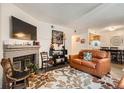 Comfortable living room with a brick fireplace, leather couch and decorative rug at 1358 S Irving St # 53, Denver, CO 80219