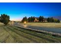 Elegant home exterior at dusk, showcasing a long driveway at 9250 Steeplechase Dr, Franktown, CO 80116