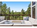 Outdoor seating with plush couches on deck overlooking mountain views and mature trees at 2122 Cramner Ct, Evergreen, CO 80439