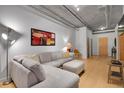 Spacious living room with bamboo floors, a comfy sectional, and industrial-style exposed ductwork at 1401 Wewatta St # 202, Denver, CO 80202