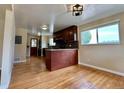 Open-concept kitchen with dark cabinetry, hardwood floors, and ample natural light at 1801 S Grove St, Denver, CO 80219