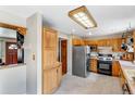 Well-lit kitchen with classic wood cabinetry, modern stainless steel refrigerator, and gas range at 9040 Raleigh St, Westminster, CO 80031