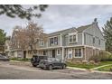 View of multiple townhouses with varied siding and stone accents on a tree-lined street with parking at 15566 E Louisiana Ave, Aurora, CO 80017