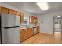 Bright kitchen with stainless steel appliances, natural wood cabinets, and hardwood floors at 127 S Perry St, Denver, CO 80219