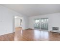 Open living room showcasing the hardwood floors and a sliding door for balcony access at 755 S Alton Way # 9D, Denver, CO 80247