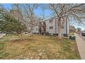 View of apartment building with bare trees and green lawn at 16259 W 10Th Ave # A4, Golden, CO 80401