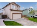 A shot of the house with an attached two-car garage and well-manicured lawn at 5039 Fontana Ct, Denver, CO 80239