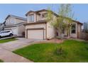 Two-story home with a manicured lawn and driveway leading to an attached two-car garage at 5039 Fontana Ct, Denver, CO 80239