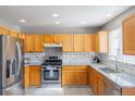 Bright kitchen features stainless steel appliances, granite countertops, and ample wooden cabinetry at 5039 Fontana Ct, Denver, CO 80239