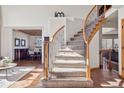 Open foyer view of dining room, staircase with wood railing and iron balusters at 8493 S Newcombe Way, Littleton, CO 80127