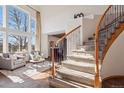 Bright foyer with hardwood floors, large windows, and a curved staircase at 8493 S Newcombe Way, Littleton, CO 80127