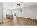 Open concept living room with hardwood floors, ceiling fan, and abundant natural light at 17962 E 94Th Pl, Commerce City, CO 80022