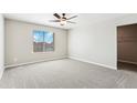 Spacious main bedroom with plush carpet, ceiling fan, and generous closet space at 17962 E 94Th Pl, Commerce City, CO 80022