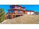 Exterior elevation showcasing a large deck, solar panels, and a two-car garage at 4586 Best Rd, Larkspur, CO 80118